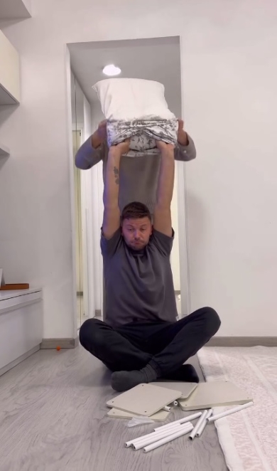 両手を挙げてカバーを持つ夫