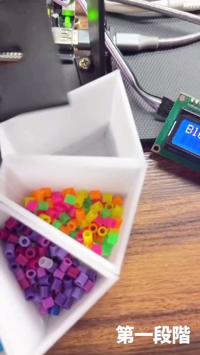 仕分け機によって分類されたネオン系の色のビーズ