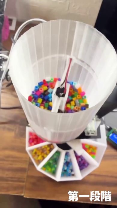 多数のアイロンビーズが入っている仕分け機上部のタンク