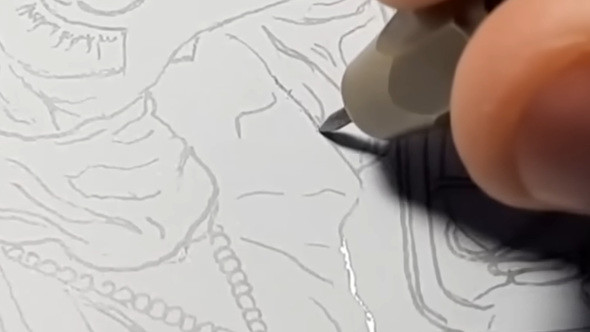 イラストの線に沿って、針のように細い道具を使って塗料を削り落とす