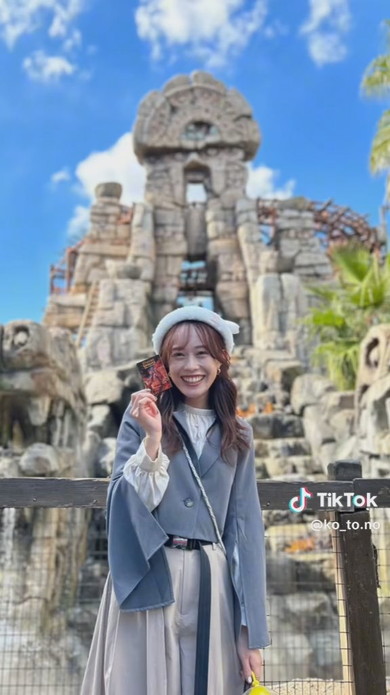 ディズニーのアトラクションをバックに撮影する女性