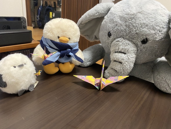 折り紙を見ているぬいぐるみたち
