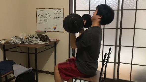 より大きいダンベルを持ち上げて腕のトレーニングを行う