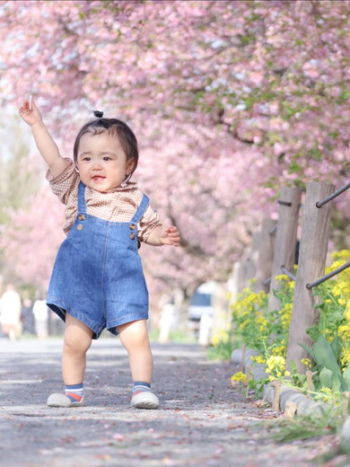 桜を背景にした1歳の女の子
