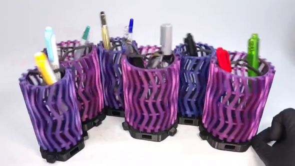 側面が歯車になっているペンスタンドを6個つなげた様子