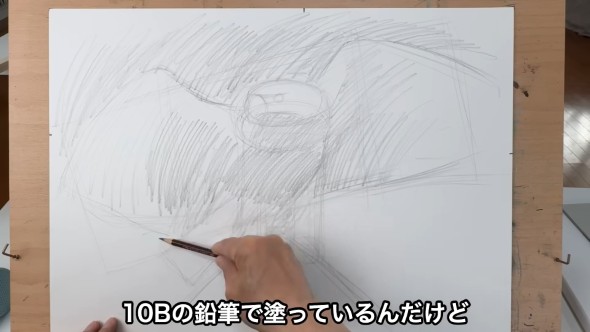 鉛筆で描かれたワシの下描きの上から濃く塗っている様子。「10Bの鉛筆で塗っているんだけど」という字幕がある。