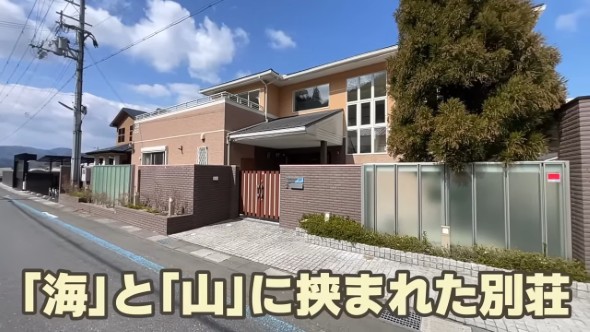 「海」と「山」に挟まれた高級感のある別荘の外観。画面下には「『海』と『山』に挟まれた別荘」というテキストが黄色で表示されている。