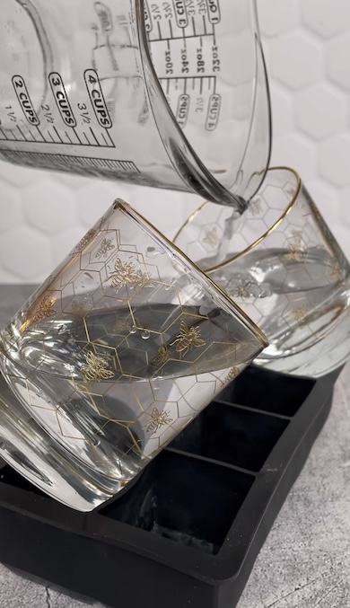 斜めのコップに水を入れているところ