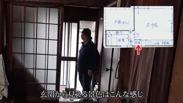 玄関から家に入る男性
