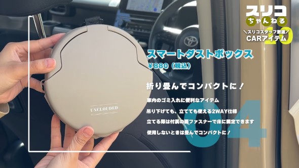 車内で使用するコンパクトなゴミ箱『スマートダストボックス』を手に持つ様子。商品名と税込価格880円が表示されており、『折り畳んでコンパクトに！』のキャッチコピーとともに、吊り下げ・自立の2WAY仕様、使用しないときは折り畳める便利さが紹介されている。