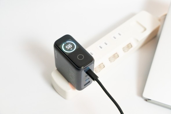 Ankerの急速充電器が電源タップに接続され、表示画面に「56W」の出力が表示されている。