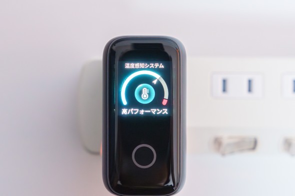 黒いAnker充電器のディスプレイに「温度感知システム」「高パフォーマンス」と表示されている様子。背景には白い電源タップが映っている。