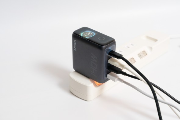 Ankerの140W充電器に4本のケーブルが接続され、電源タップに挿された状態で合計出力「114W」がディスプレイに表示されている。