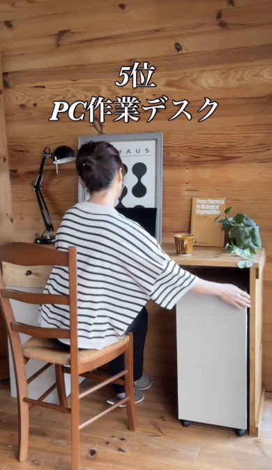 「5位 PC作業デスク」と書かれた画像。ボーダーシャツの女性が、木の机に組み込まれた白いキャスター付き収納を引き出している。